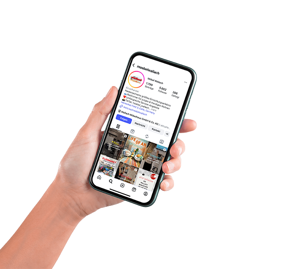 Das Bild zeigt eine Hand die ein Smartphone hält mit dem Insta-Accunt von Möbel Wallach